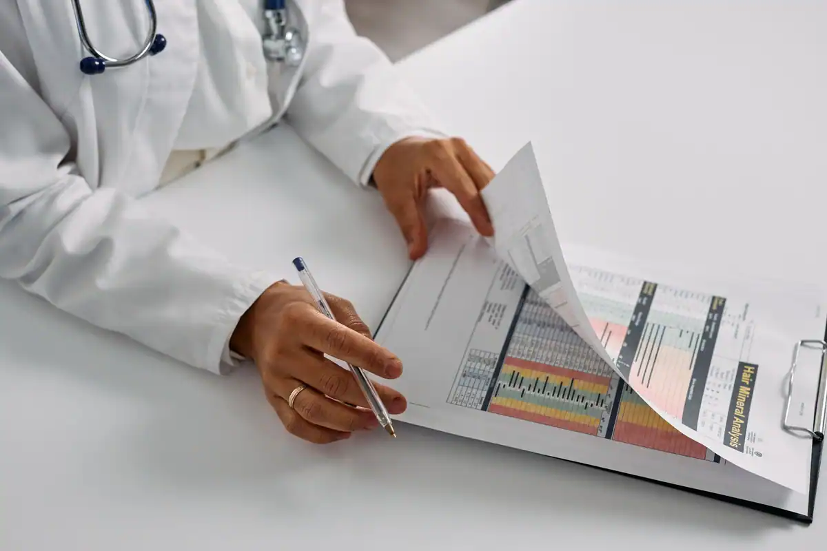 Medic care analizează rezultatele analizelor unui pacient pe un clipboard