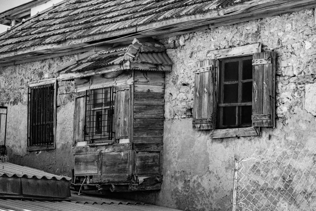 Casă veche de țară cu obloane de lemn, fotografiată alb-negru