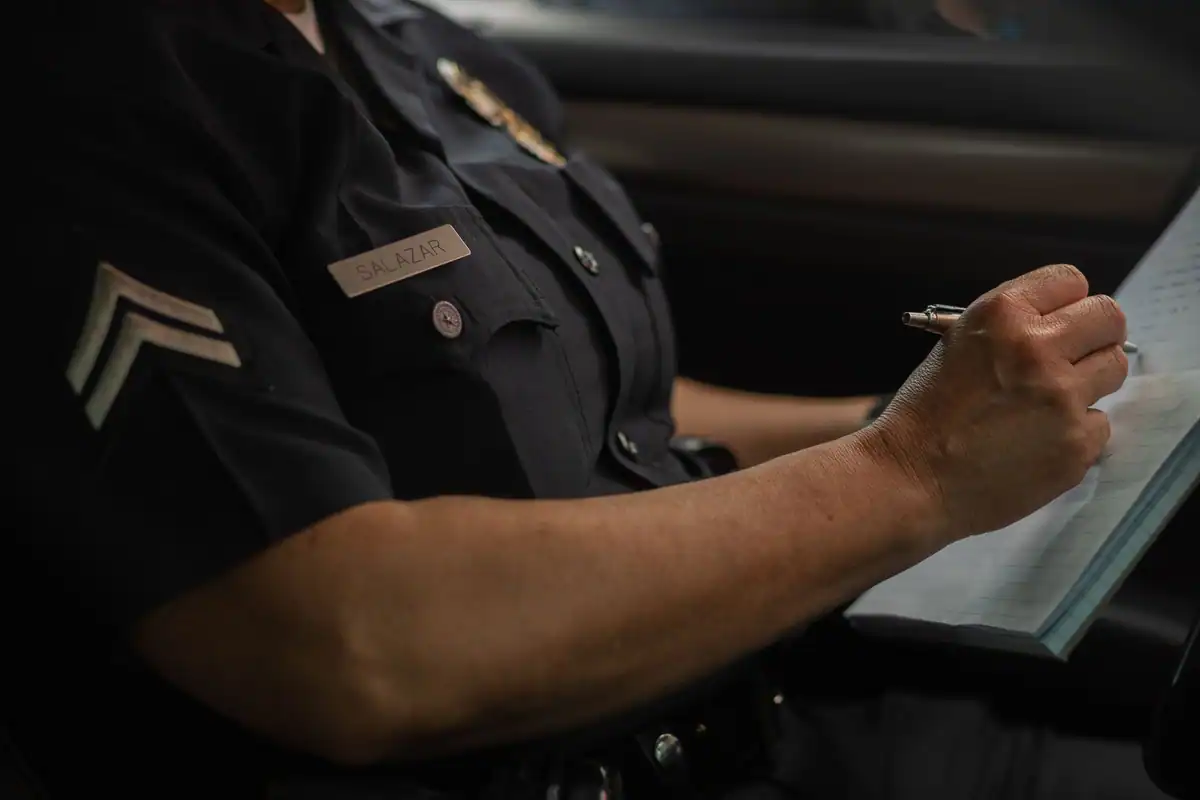 Polițist care notează detaliile unei sesizări de furt în mașina de patrulare