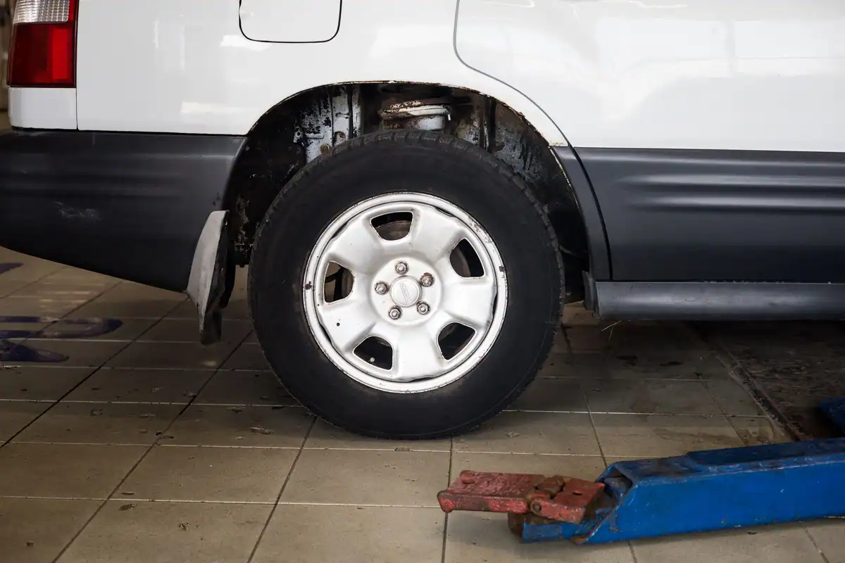 Roată de mașină ridicată pe cric într-un atelier de reparații auto
